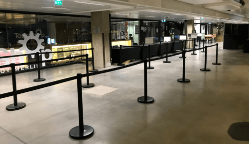 Vue d’un vestiaire événementiel organisé avec des potelets et guides de file, facilitant la circulation des participants et optimisant la gestion des files d’attente.